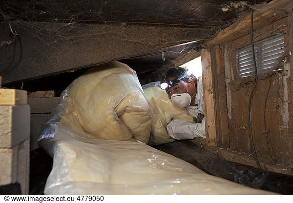 'Steve Gutierrez  a worker with Veterans Green Jobs  installs insulation in the crawl space below a mobile home