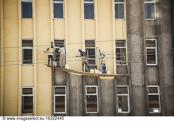 Äthiopien  Addis Abeba  Vier Männer streichen Hausfassade