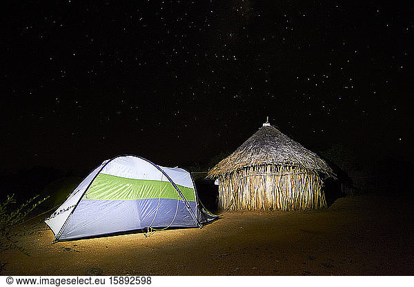 Äthiopien  Turmi  Zelt nachts neben traditioneller afrikanischer Hütte aufgebaut
