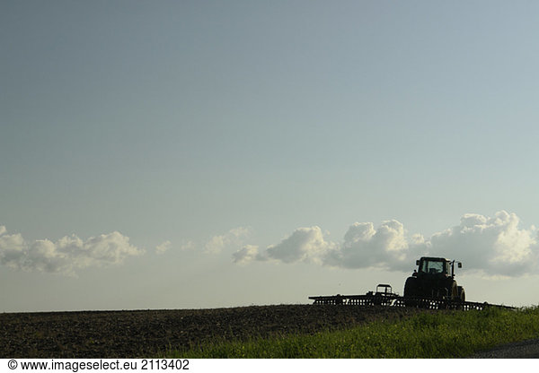 'Tractor with cultivator at the edge of a field