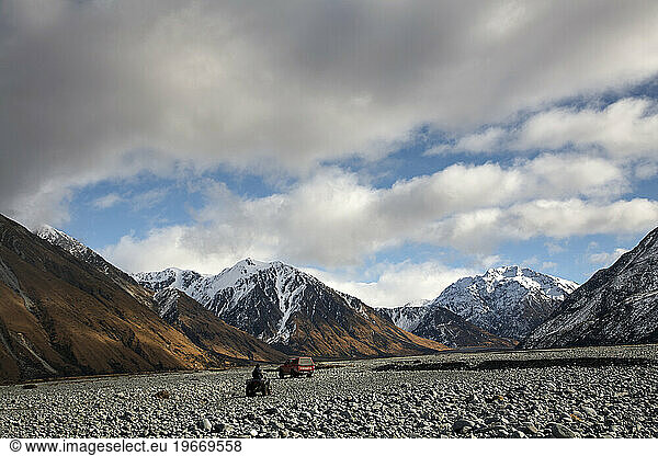 4x4 car and quadbike driving in rocky scenery with mountains during hunting trip  New Zealand