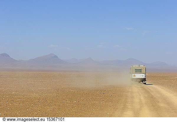 4x4-Fahrzeug auf einer staubigen Schotterpiste in Wüstenlandschaft  Kaokoveld  Namibia  Afrika