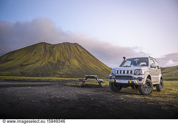 4x4 neben dem Picknicktisch vor dem Berg neben dem Fluss geparkt