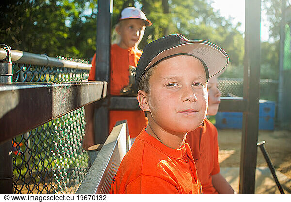 10 YEAR OLD boy on the little league team in the DUGOUT