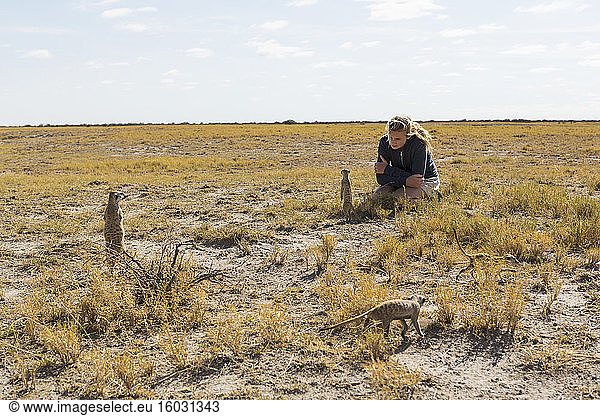 12 year old girl looking at Meerkats  Kalahari Desert
