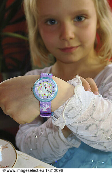 4-5 year old girl with her watch to learn the time