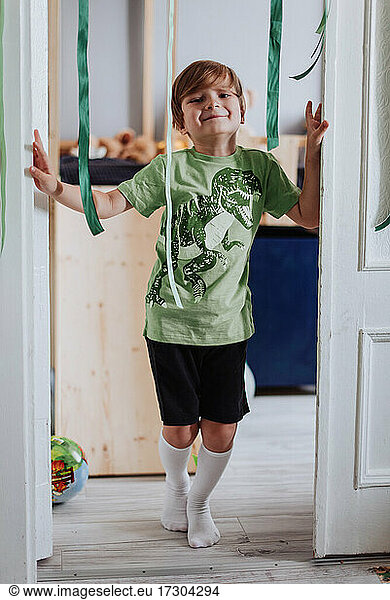 5 years boy playing in his room  wearing green t-shirt with dinosaurus print