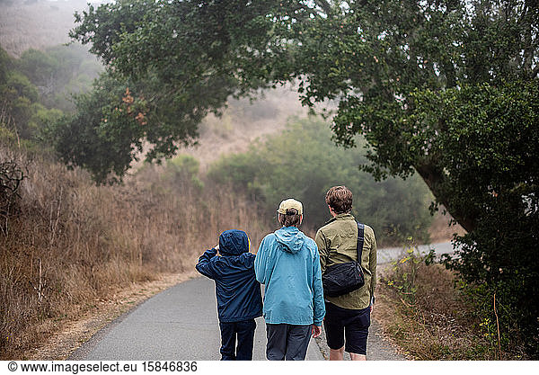 3 young men hiking on foggy trail