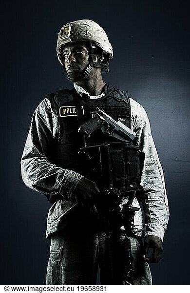 A African American  male  Air Force Security Forces Airman in uniform poses with his M-9 pistol.