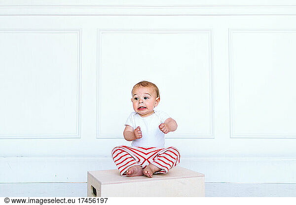 A baby boy makes a funny face in a photo studio