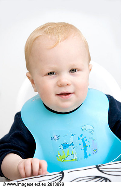 A baby boy wearing a bib Sweden.