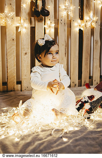 a baby girl in a photo set taking christmas photos
