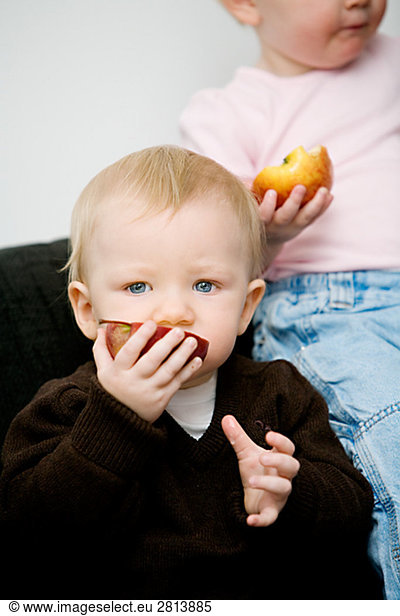 A baby holding an apple Sweden.
