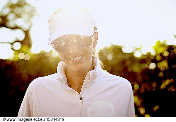 A backlit portrait of an athletic woman.