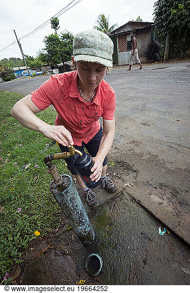 A backpacker gets water from a local tap in the Kalinago territory on Segment 6 of the Waitukubuli National Trail on the Caribbean island of Dominica.