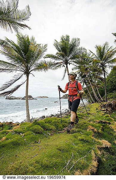 A backpacker hikes next to the Atlantic Ocean on Segment 6 of the Waitukubuli National Trail on the Caribbean island of Dominica.
