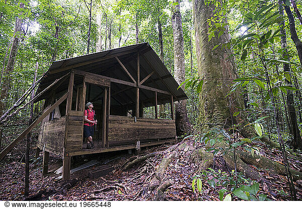 A backpacker stands in a shelter along Segment 8 of the Waitukubuli National Trail on the Caribbean island of Dominica. This shelter is one of the only backcountry shelters along