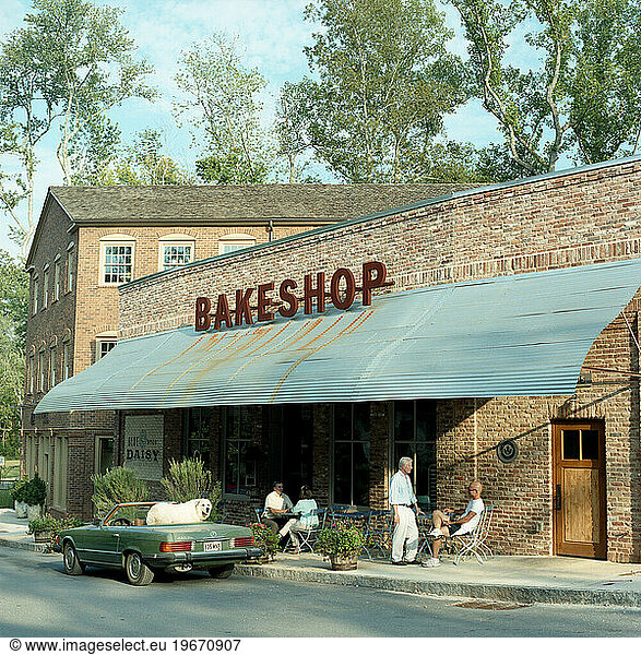 A bakeshop in a small community draws residents and a convertible green car.