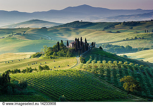 A beautiful and lonely farmhouse surrounded by green hills  Orcia Valley  Tuscany  Italy