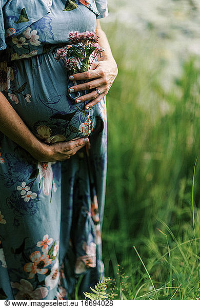 A beautiful pregnant woman holding her growing belly