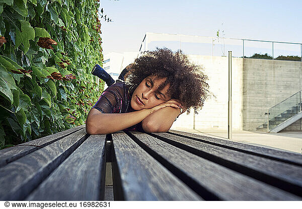 A beautiful woman lying in a park.She has beautiful afro hair.