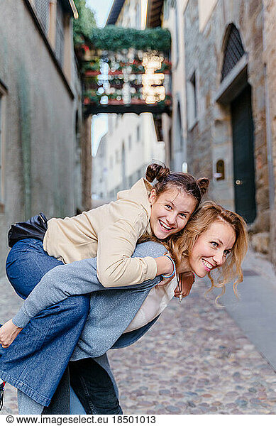 A blond woman and a teenage daughter are walking in an old town