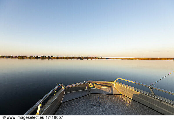 A boat on the waters of Okavango Delta at sunset  flat calm water