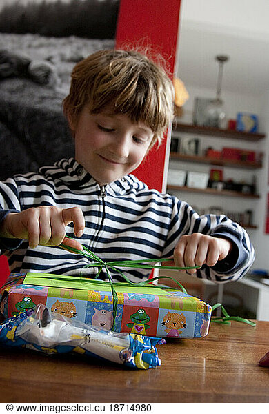 A boy excitedly opens a gift