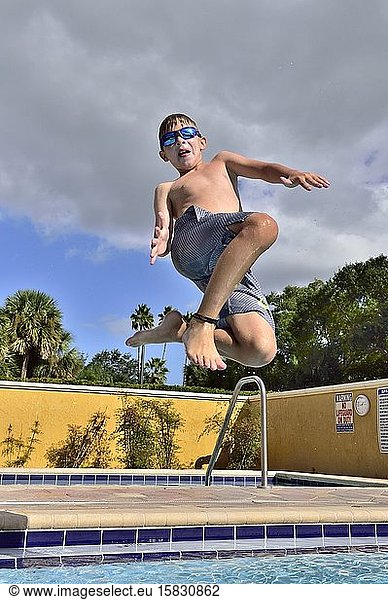 A boy jumps into a hotel pool on vacation in Florida