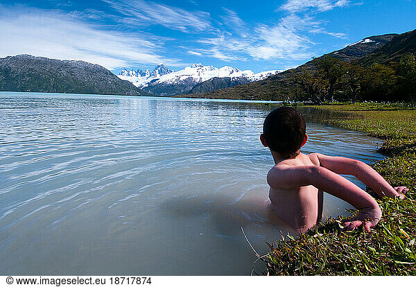 A boy plays in the icy glacial waters of Lake O'Higgins  Chile.
