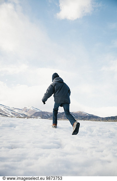 A boy running away across the snow.