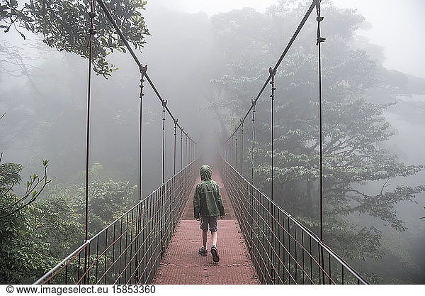 A boy walks across a bridge in the Monteverde Cloud Forest