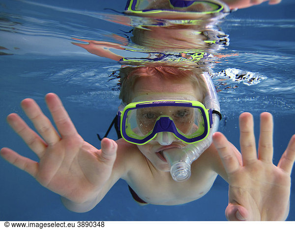 A boy  6 years  diving with diving goggles and snorkel