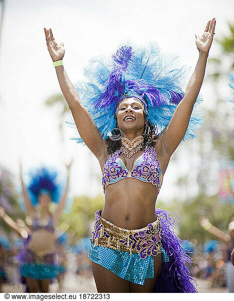 A Brazilian dancer performs at a parade in Santa Barbara. The parade features extravagant floats and costumes.