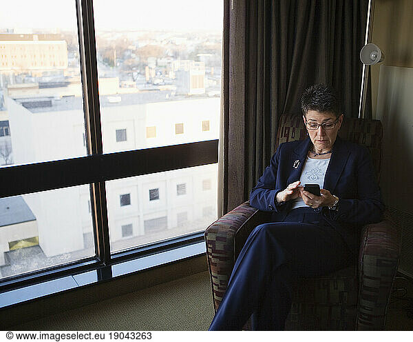 A business woman checks her cell phone messages.