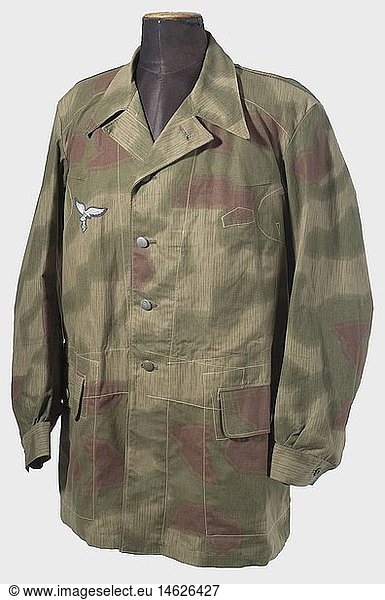 A camouflage jacket of the Luftwaffe Field Division.  Half-long jacket of several fabrics  printed on one side in 'Sumpftarn' (water) camouflage pattern  machine-embroidered breast eagle on blue backing. Metal buttons. No lining  the pockets of brown cotton cloth with RB number and a size stamp. Unworn  fresh colours. historic  historical  1930s  20th century  Air Force  branch of service  branches of service  armed service  armed services  military  militaria  air forces  object  objects  stills  clipping  clippings  cut out  cut-out  cut-outs  uniform  uniforms  clothes  textile  outfit  outfits  wearings  camouflage  camouflages