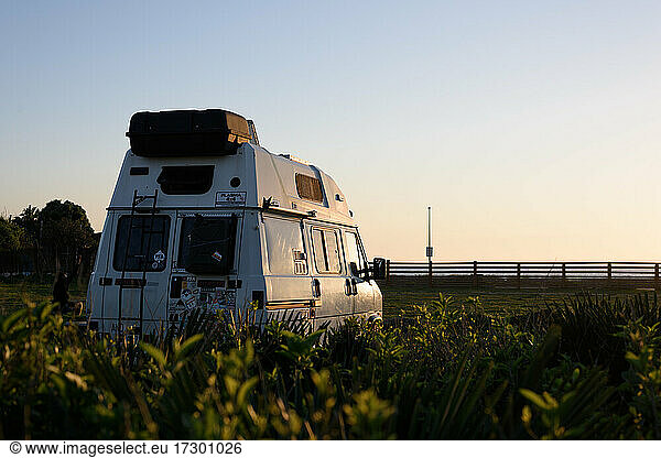 A camper van on the coas on the sunset