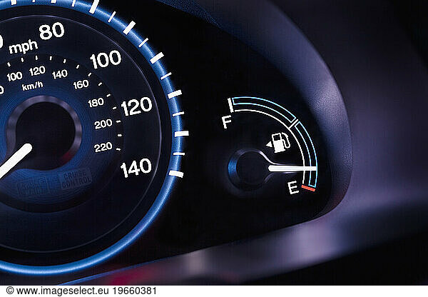 A car interior  the dashboard instrument panel and fuel gauge. A speedometer.