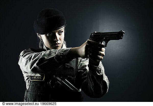 A Caucasian  female  Air Force Security Forces Airman in uniform poses with her M-9 pistol.