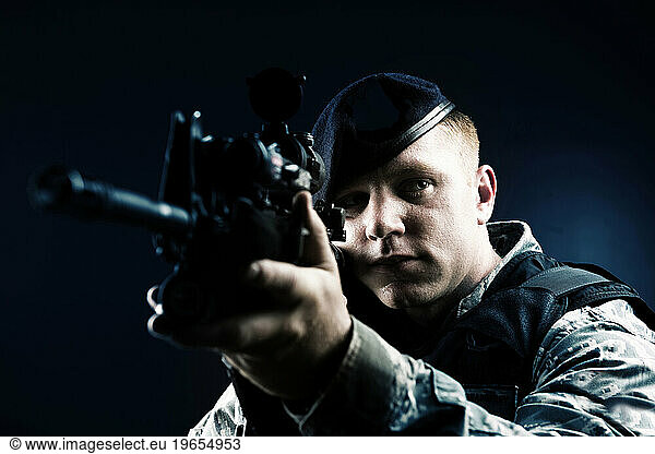 A Caucasian  male  Air Force Security Forces Airman in uniform poses with his M-4 rifle.