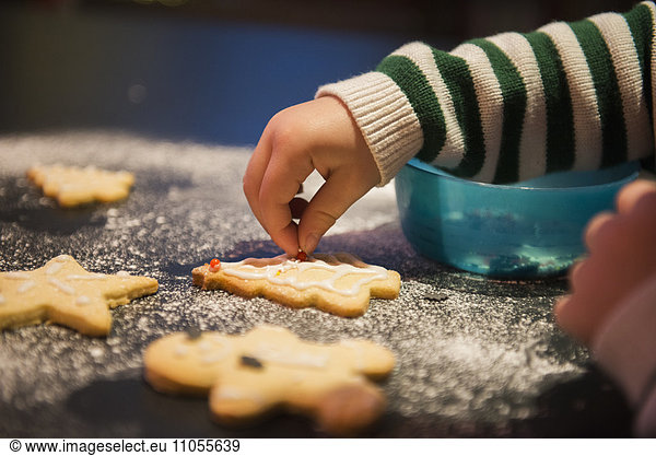 A child decorated Christmas biscuits.