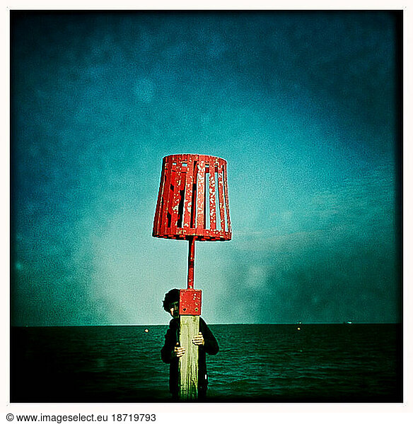 a child hides behind a jetty over the sea at Cleethorpes England UK Europe