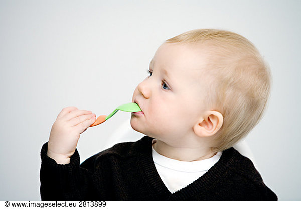 A child holding a spoon to his mouth Sweden.
