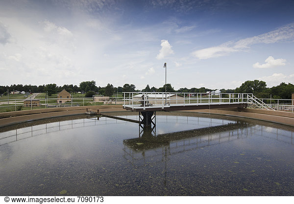 A circular cleaning system with a raised platform over a Waste Water Treatment System.