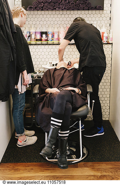 A client at a hair salon having her hair washed.