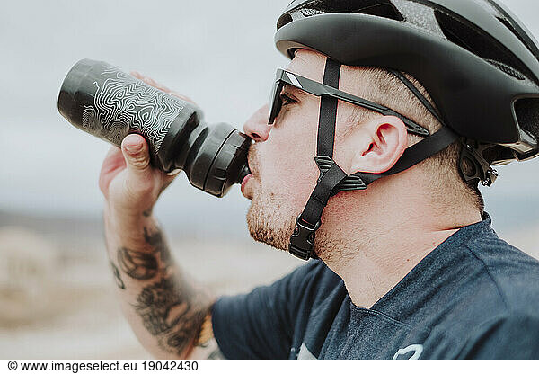 A close portrait if a cyclist man drinking water in Tenerife