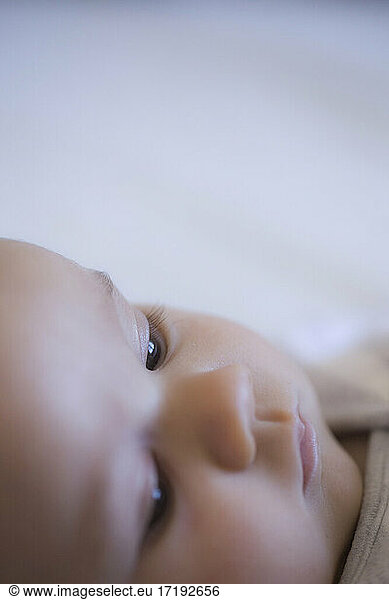 A close up portrait of a baby's face on a plain background
