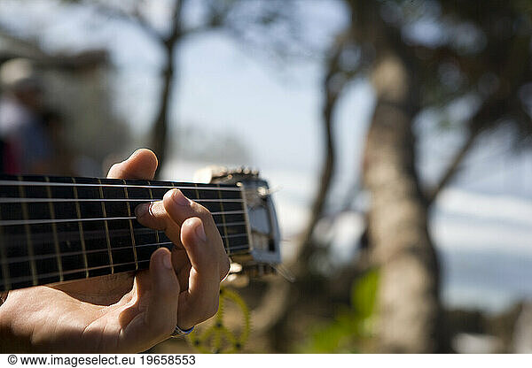 a closeup of fingers playing a ukulele