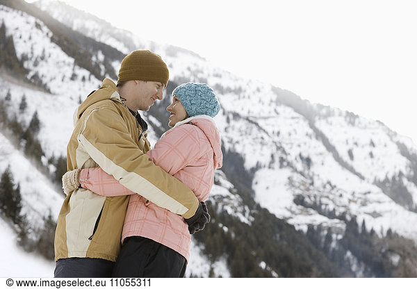A couple  a man and woman in the snowy mountains.