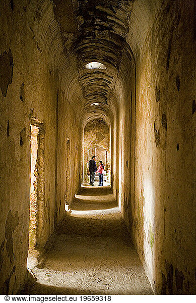 A couple in a hallway of the ruins of the old church Santa Clara  Antigua  Guatemala